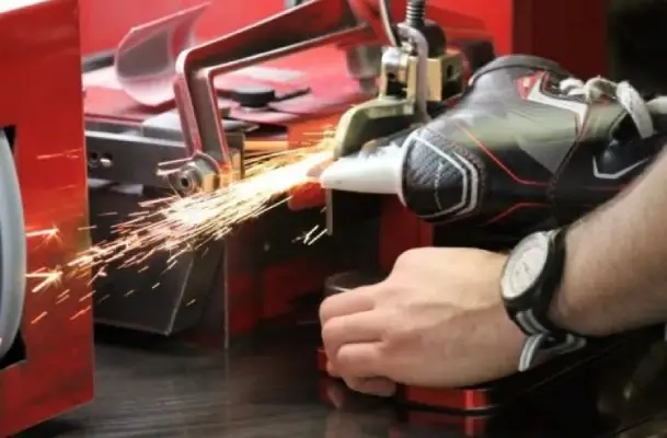 Hand Skate Sharpening Ski equipment lies on untouched snow, surrounded by majestic mountains under a clear sky.