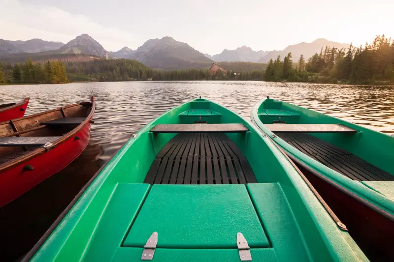 RENTALS FOR SUMMER Stunning mountain lake with colorful wooden boat. National Park High Tatras, Strbske Pleso, Slovakia, Europe